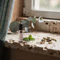 Prana Durchatmen-Roll-on auf Kalkstein am Fenster mit Eukalyptus, Pfefferminze und Kardamom