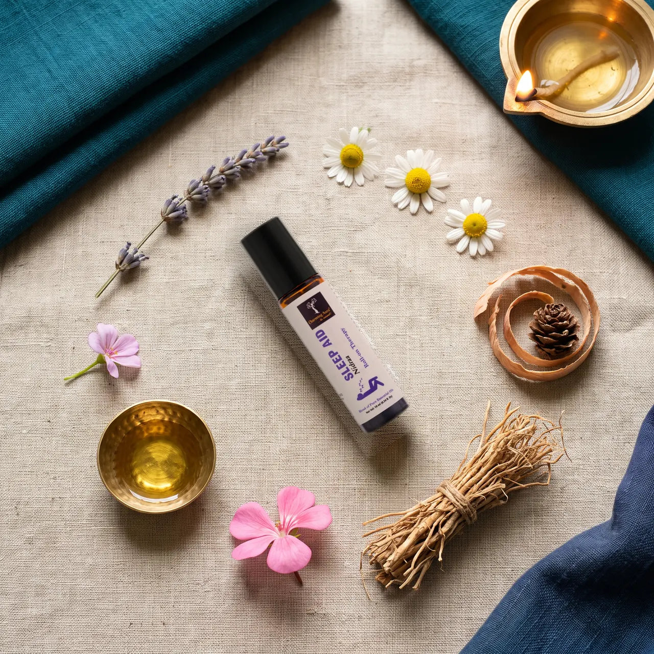 Nidraa Roll-on, umgeben von Lavendel, Kamillenblüten, Zedernholz, Vetiverwurzeln und Geranie